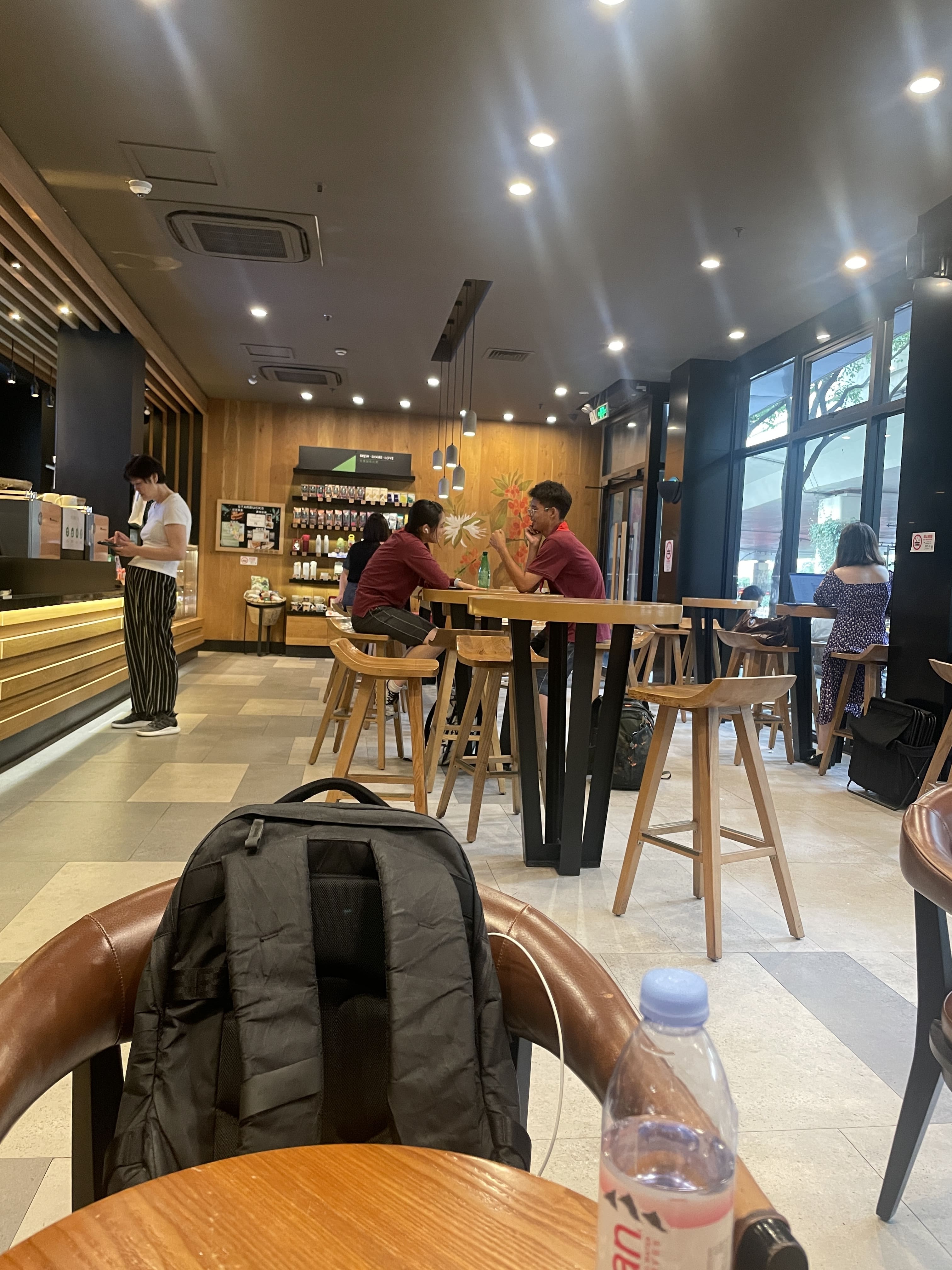A sweet high school couple arm wrestling at Starbucks (dating?)